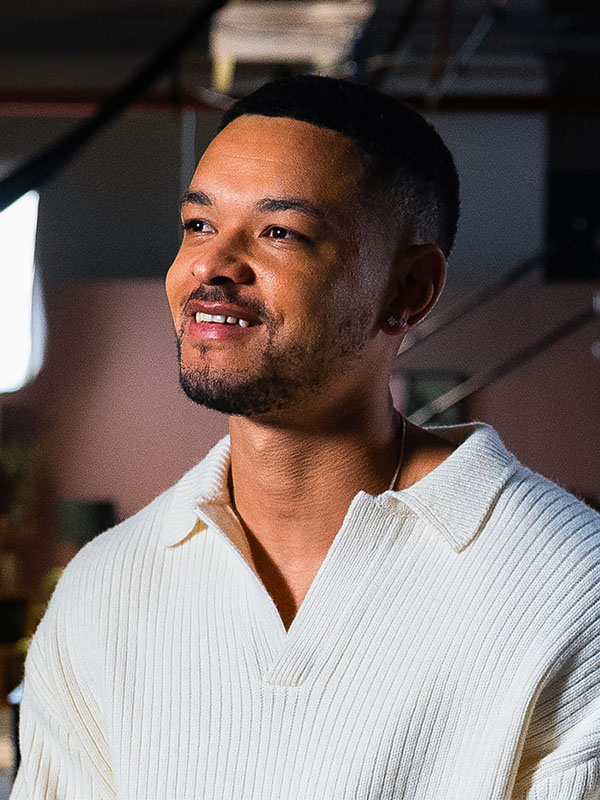 A headshot of steven barlett smiling in a white knit jumper